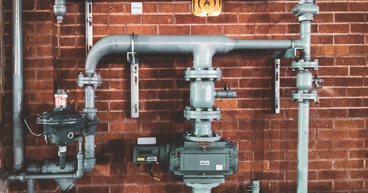 Close-up of a water heater's connections and valves during maintenance